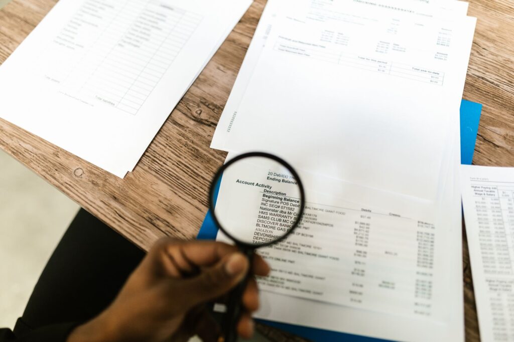 Examen à la loupe d'un dossier de conformité, illustrant l'audit des 32 indicateurs Qualiopi