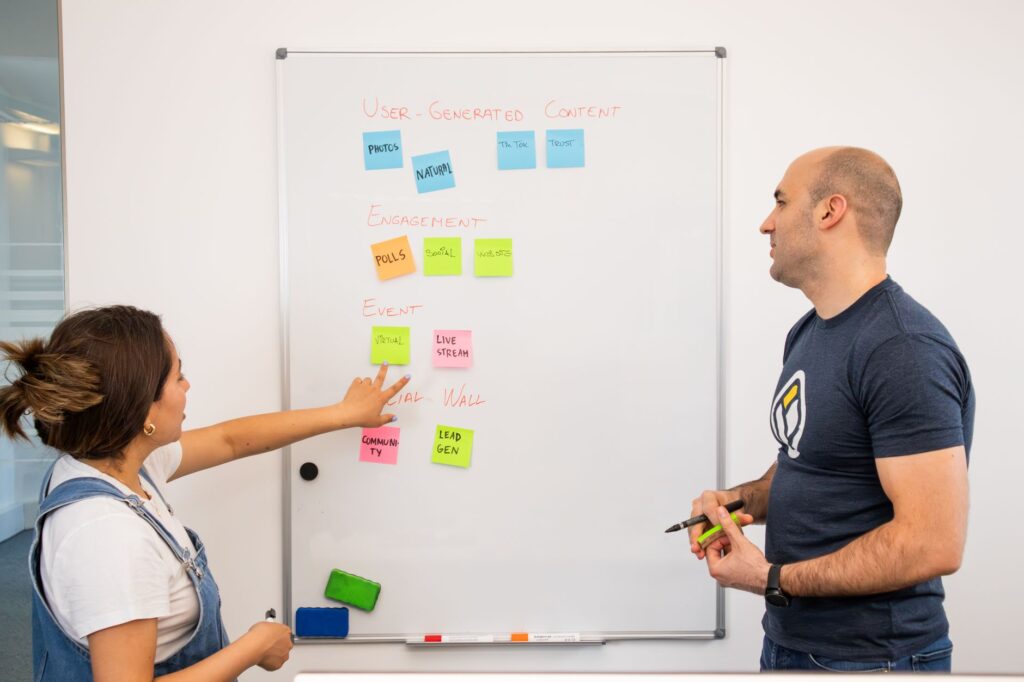 Deux formateurs planifient la structure d une formation etape par etape sur un tableau blanc