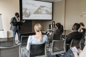 Formateur animant une session de formation devant un groupe de professionnels en salle