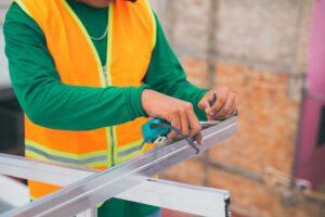 Formateur BTP en gilet de sécurité prenant des mesures, étude de cas exonération de TVA