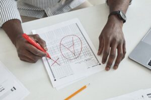 Formateur corrigeant une copie d'évaluation au stylo rouge