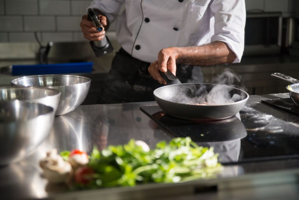 Chef en cuisine professionnelle transmettant son savoir-faire