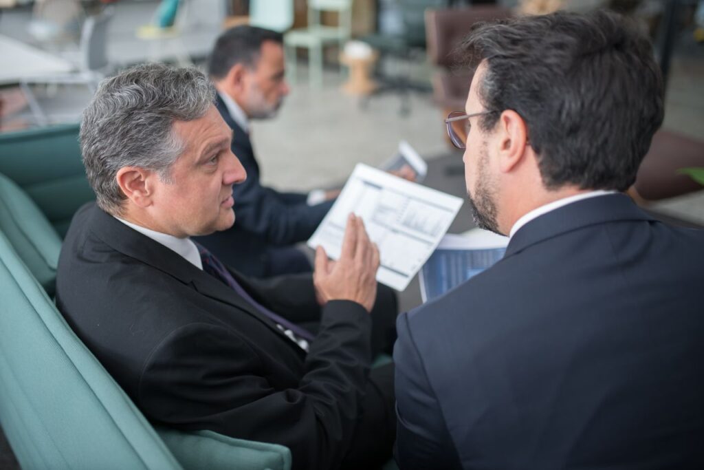 Deux professionnels analysant des documents dans un bureau moderne, illustration de la préparation de la certification Qualiopi
