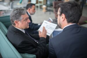 Deux professionnels analysant des documents dans un bureau moderne, illustration de la préparation de la certification Qualiopi