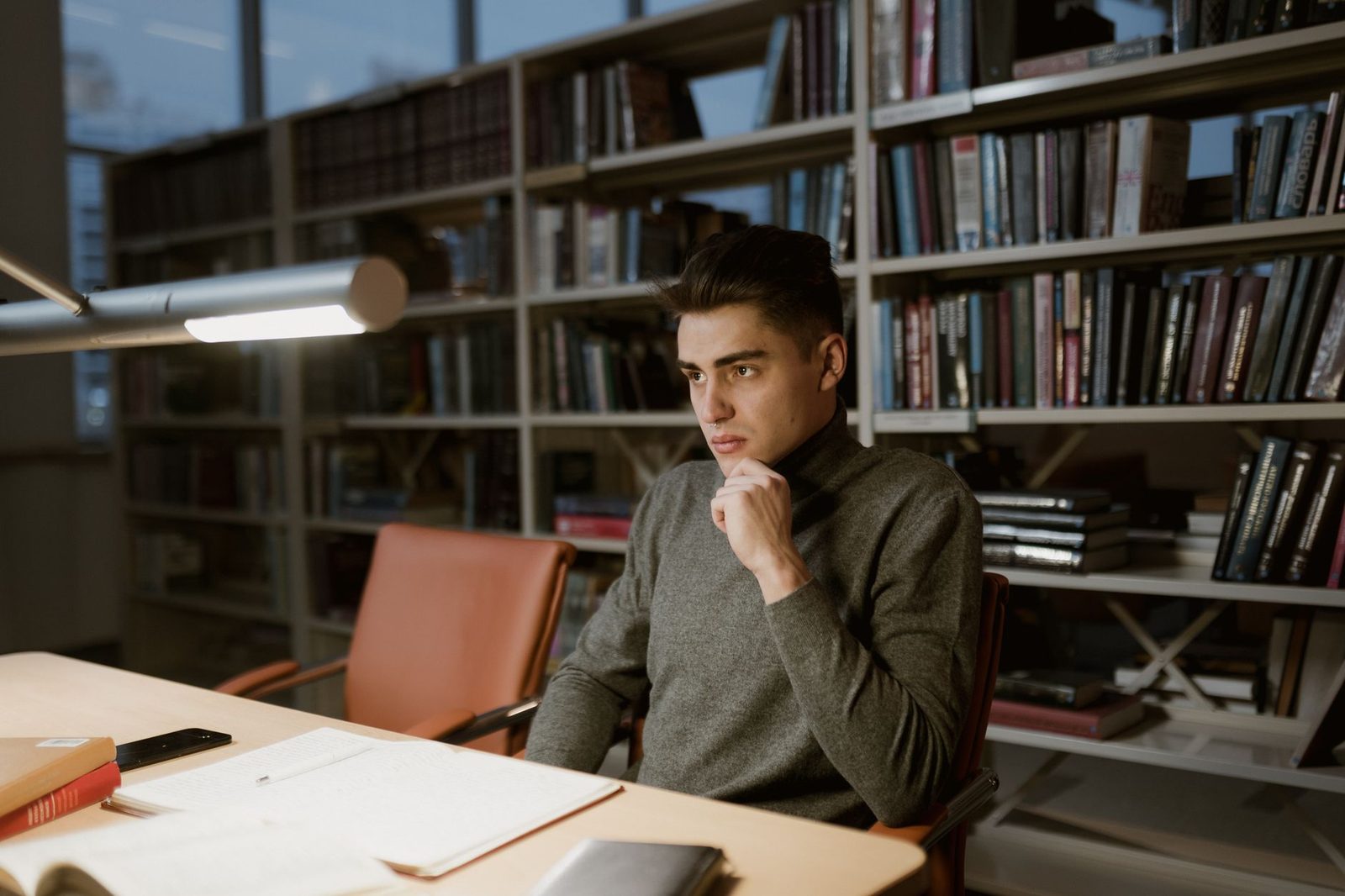 Étudiant en réflexion dans une bibliothèque, les niveaux d'apprentissage en pratique