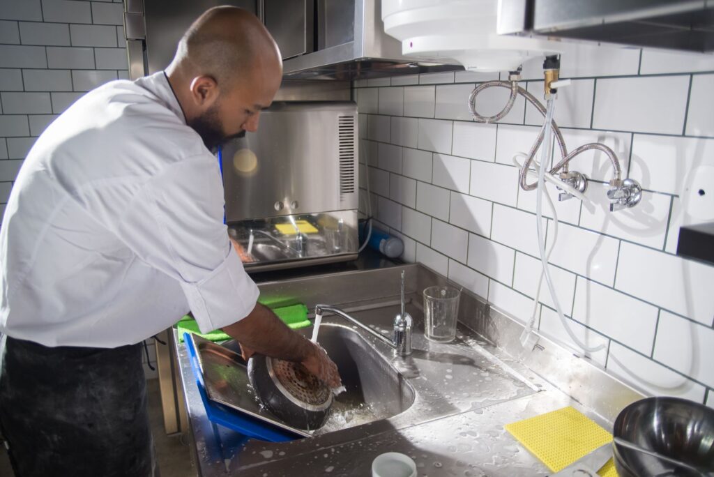 Chef nettoyant son poste de travail en cuisine professionnelle