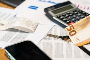 Documents financiers, billet en euros et calculatrice pour estimer le reste à charge CPF