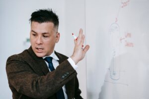 Formateur présentant ses idées sur un tableau blanc devant un groupe en salle de formation